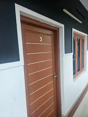 a brown door in a room with a window at grandresidency in Kāladi