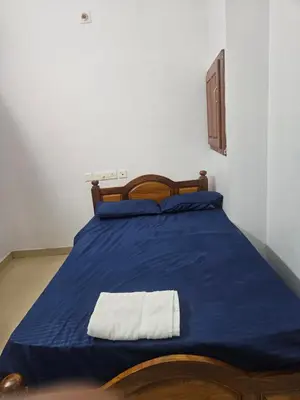 a bedroom with a blue bed with a towel on it at grandresidency in Kāladi