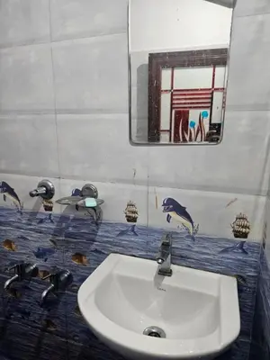 a bathroom with a sink and a mirror at grandresidency in Kāladi
