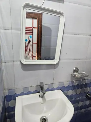 a bathroom with a sink and a mirror at grandresidency in Kāladi