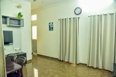 a room with curtains and a clock on a wall at Mysuru Family Home Stay in Mysore