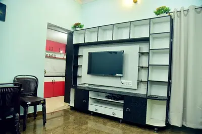 a entertainment center with a television in a room at Mysuru Family Home Stay in Mysore