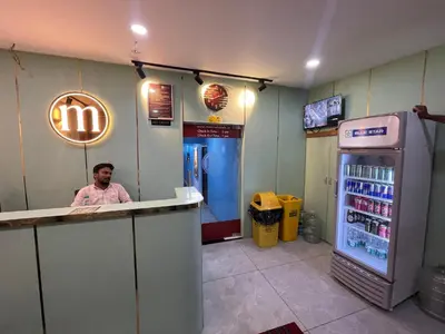 a man sitting at a counter in a fast food restaurant at The Marina Kozhikode AC Rooms and Dorms Opposite to Beach in Kozhikode