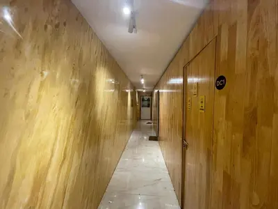 a corridor of a hallway with wooden walls and a door at The Marina Kozhikode AC Rooms and Dorms Opposite to Beach in Kozhikode