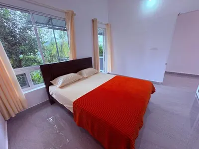 a bedroom with a bed with a colorful blanket at Eve's Residency in Meppādi