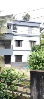a large white building with a lot of windows at Eve's Residency in Meppādi