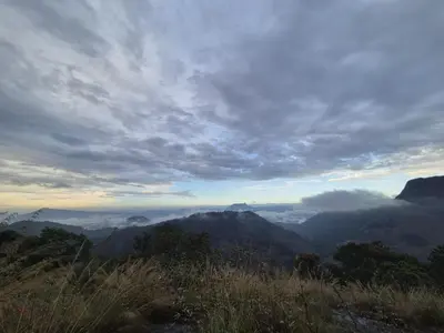 a view of a mountain range with clouds in the sky at Mamalakandam Rock Cave at Diya Homestay in Mamalakandam