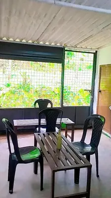 a bench and two chairs and a table and a window at Mamalakandam Green Hill Stay in Diya Homesay in Mamalakandam
