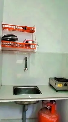 a kitchen counter with a sink and a shelf at Mamalakandam Green Hill Stay in Diya Homesay in Mamalakandam