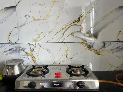 a kitchen with a stove top with a marble wall at AC 3BHK premium house in Pollāchi