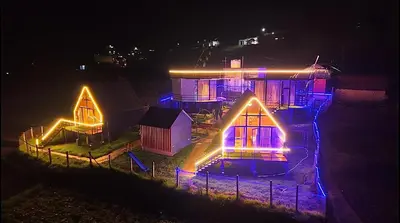 a house with lights on it at night at Airas Resort in Kūkkāl