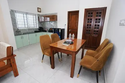 a kitchen with a wooden table and chairs at Samruddhi Service Apartments in Mysore