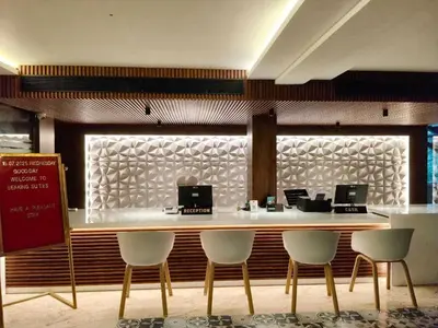 a restaurant with a bar with four chairs and a counter at Townhouse Kozhikode Beach Formerly Point Avenue in Kozhikode