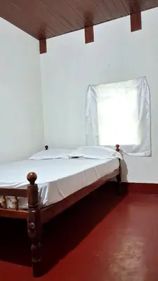 a small bed in a room with a window at Pookie stay athirapilly in Athirappilly