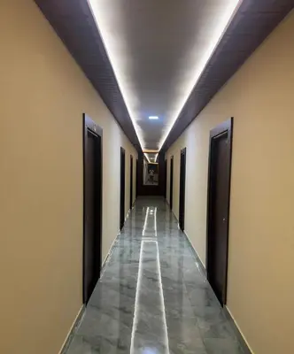 a hallway with a long corridor with doors and a tile floor at Ridhis Stay in Virajpet