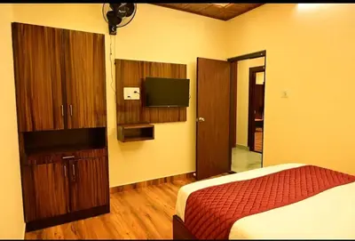 a hotel room with a bed and a television at Ridhis Stay in Virajpet
