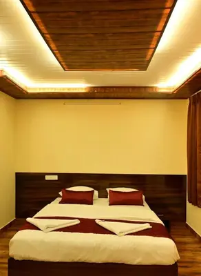 a bedroom with a large bed with red pillows at Ridhis Stay in Virajpet