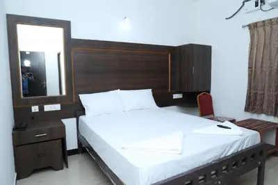 a bedroom with a large bed with a mirror and a mirror at Hotel Aranmanai in Coimbatore