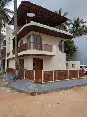 a house with a balcony and a palm tree at Auric by Hillton in Mysore