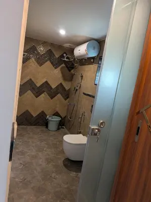 a small bathroom with a toilet in a room at Auric by Hillton in Mysore