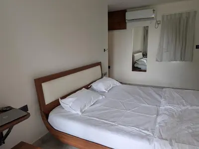 a bedroom with a white bed with a mirror at Auric by Hillton in Mysore
