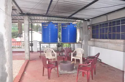 a group of chairs and blue barrels in a building at HS Cottage Ooty in Ooty