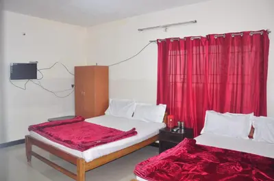 two beds in a room with a red curtain at HS Cottage Ooty in Ooty