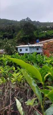 a house in the middle of a field of plants at Hanni Resort in Kotagiri