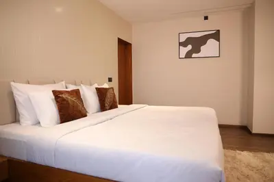 a bedroom with a large bed with white sheets and pillows at Hills and Hearts Luxury Villa in Coonoor