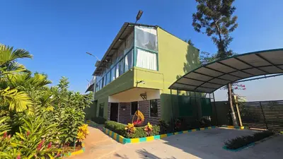 a yellow and green building with a large window at Nature's Spark Resort in Sivasamudram