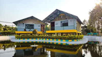 a house next to a body of water at Nature's Spark Resort in Sivasamudram