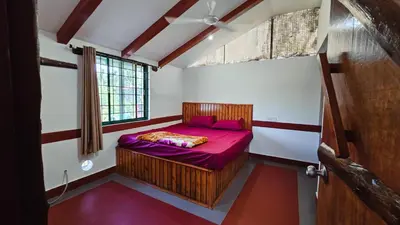 a bedroom with a bed with purple sheets and a window at Nature's Spark Resort in Sivasamudram