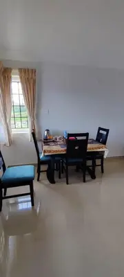 a dining room with tables and chairs and a window at Noori Home Stay - 2BH in 1st Floor Near Ooty in Ooty