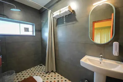 a bathroom with a sink and a mirror at Sreenivas Lodge by Copperfolia in Kozhikode