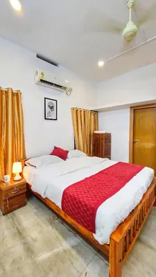 a bedroom with a large bed with a red blanket at TS Club in Trichūr
