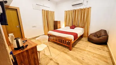 a bedroom with a bed and a chair and a desk at TS Club in Trichūr