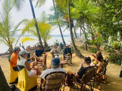 a group of people sitting in chairs on the beach at Green Island homestay in Kadalundi