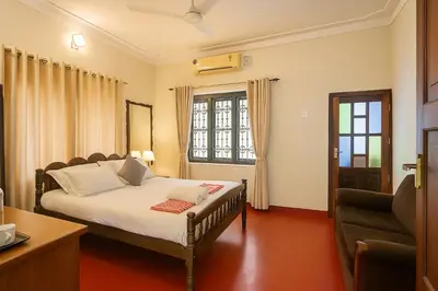 a bedroom with a bed and a window at Haris Farm House in Kannur