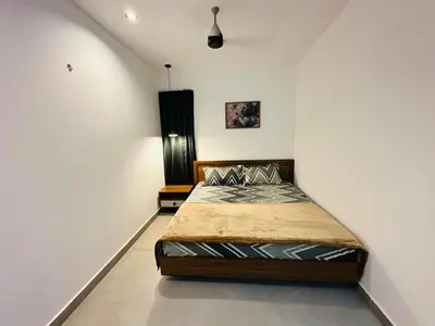 a bedroom with a bed in the corner of a room at ZAHIR RESIDENCY calicut in Kozhikode