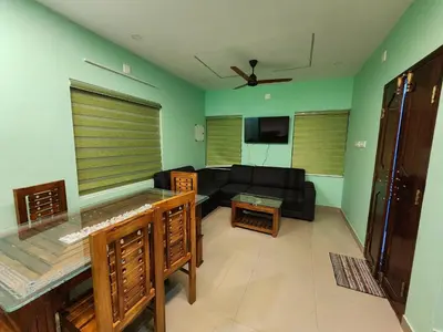 a living room with a black couch and a tv at ILANJI TREE Inn in Cochin