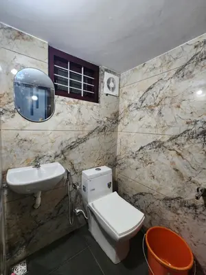 a bathroom with a white toilet and a sink at ILANJI TREE Inn in Cochin