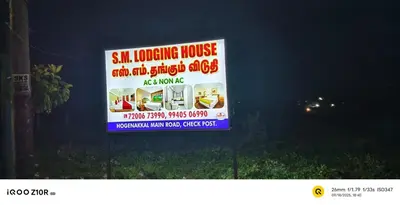 a sign is posted on a fence in front of a house at S M LODGe in Dharmapuri