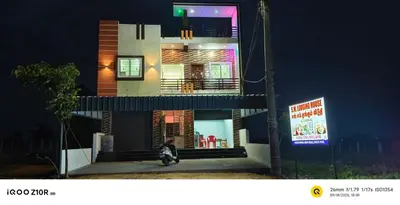 a dog sitting in front of a building at night at S M LODGe in Dharmapuri