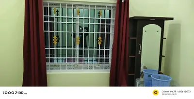 a window in a room with red curtains at S M LODGe in Dharmapuri