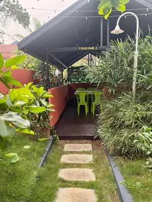 a patio with green chairs and a black canopy at Skylark Home in Mananthavady