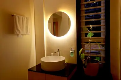 a bathroom with a sink and a mirror at Skylark Home in Mananthavady