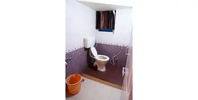 a bathroom with a toilet and a window in it at KP Holidays తెలుగు Cottage in Ooty