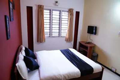 a bedroom with a bed and a window at KP Holidays తెలుగు Cottage in Ooty