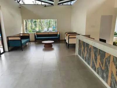 a room with couches and chairs and a table at Half Moon Resort Vythiri by Z Vacations in Vayittiri