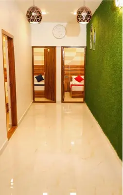 a hallway with green walls and a clock on the wall at Aps inn munnar in Munnar